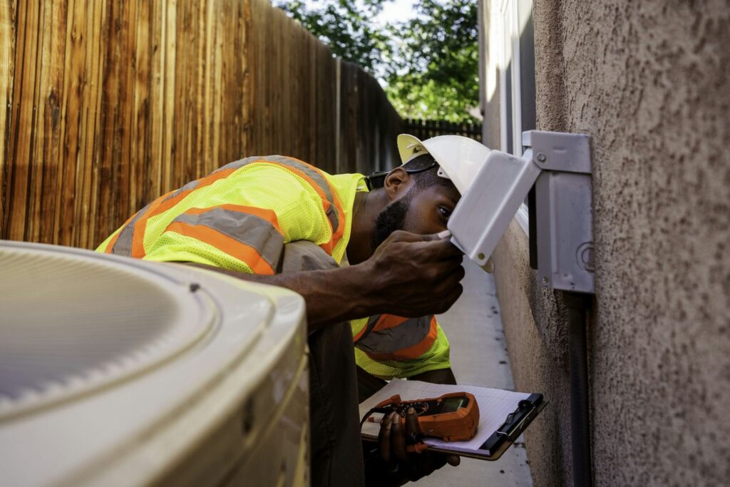 hvac tech exploring problems with AC unit