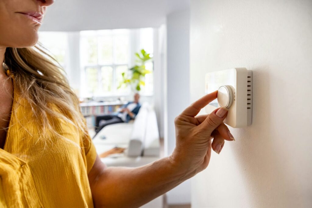 woman adjusting ac thermostat