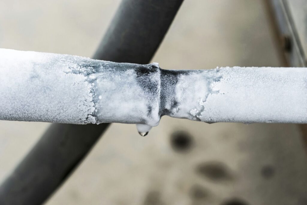 Ice buildup on an air conditioner refrigerant line as a sign of a possible leak