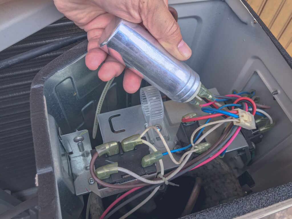 Capacitor, contactor, and wiring inside an AC condenser, the parts behind a non-spinning fan