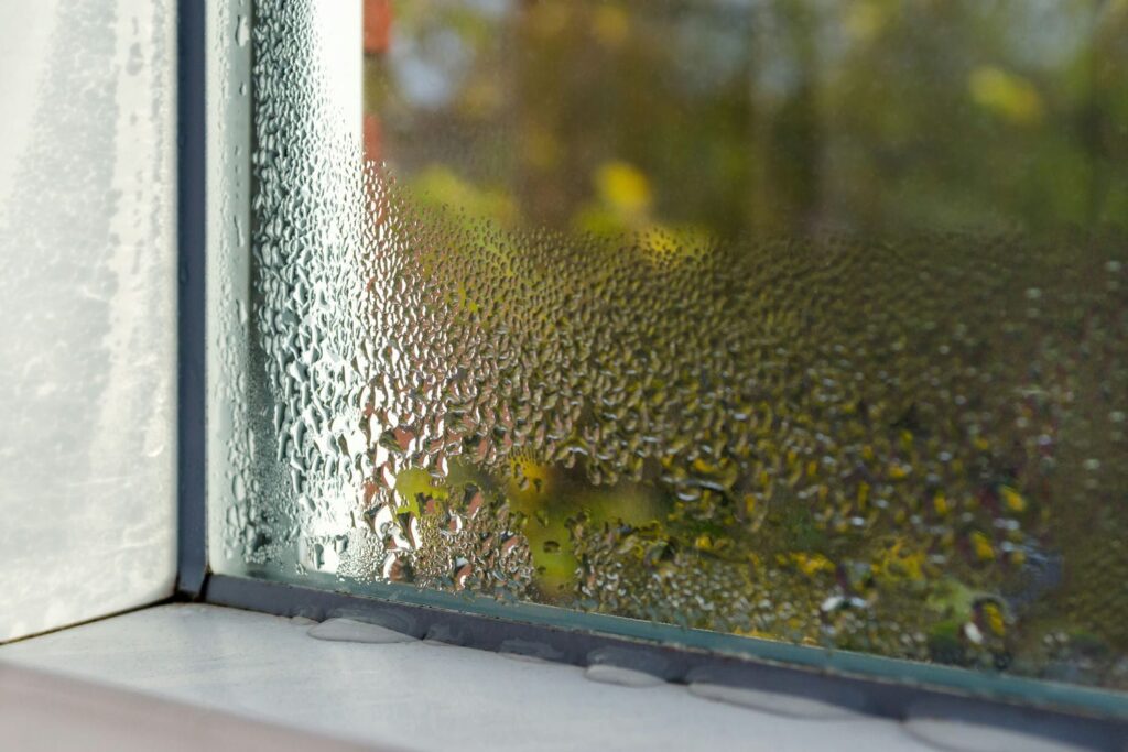 Condensation on interior windows of an Ontario home showing humidity remaining despite the AC running