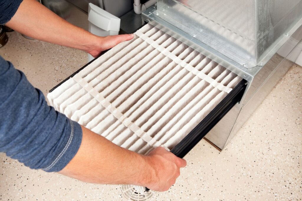 Homeowner changing furnace filter in attempt to solve humidity issues