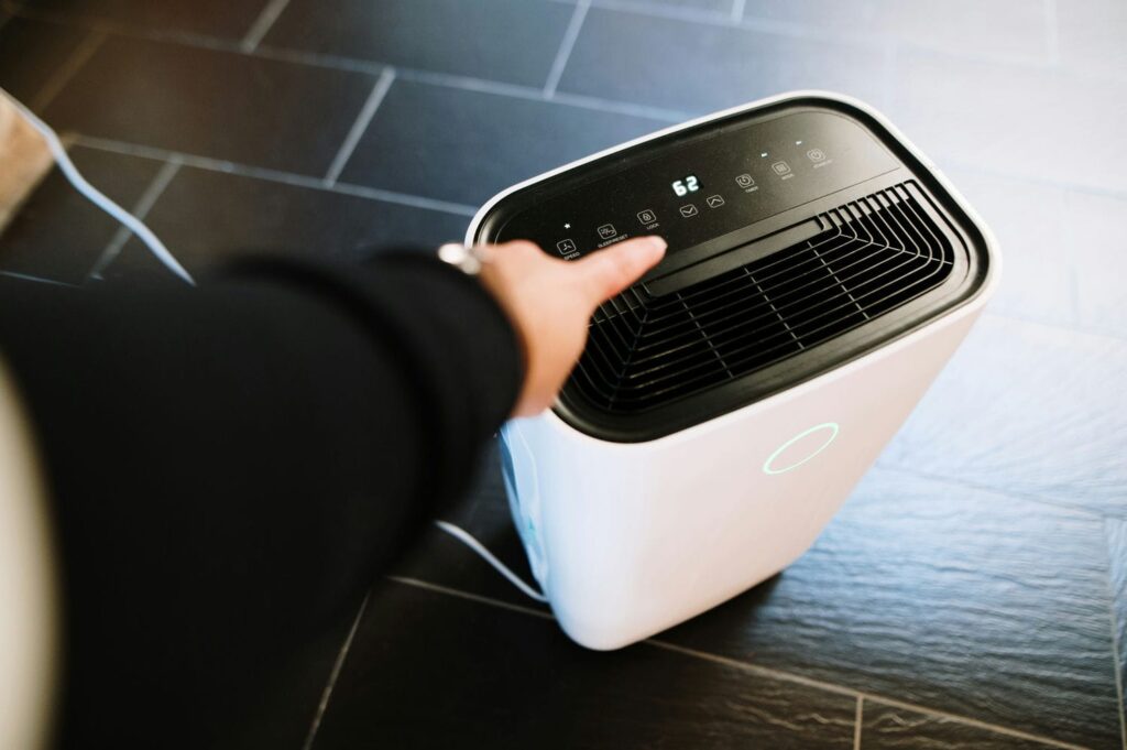 Portable dehumidifier in a home showing an elevated humidity reading that suggests a house-wide moisture load